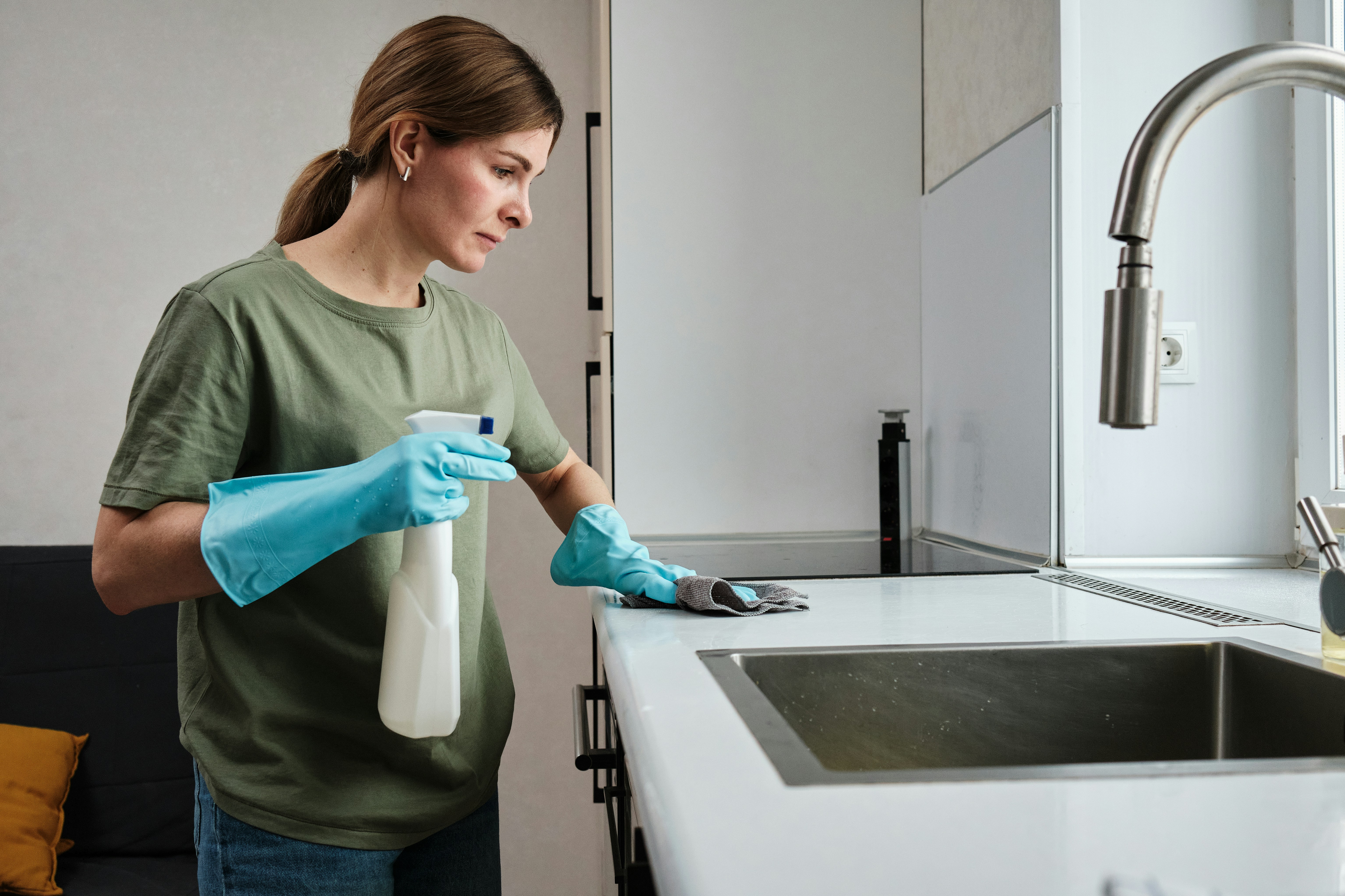 Cleaner wiping a modern kitchen worktop during a deep clean